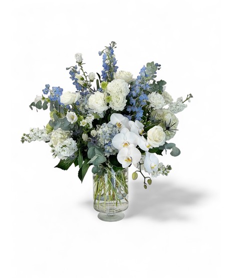 Blue and white hydrangea and more in a clear glass vase