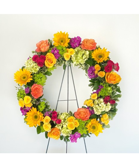 A celebration of life, wreath featuring sunflowers, hydrangea, fragrant stock, and roses