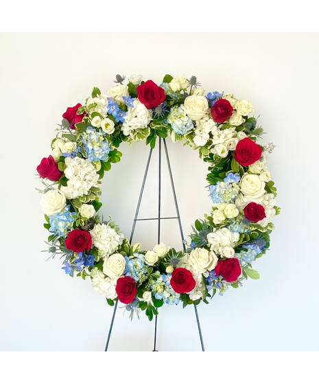 red white and blue flowers with greenery in a wreath