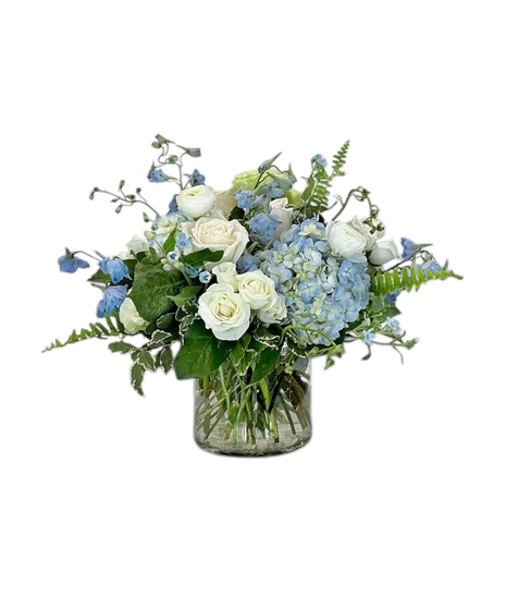 White and blue blooms arranged in a clear glass vase
