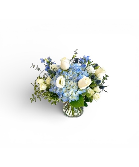 Blue and white hydrangea and more in a clear glass vase