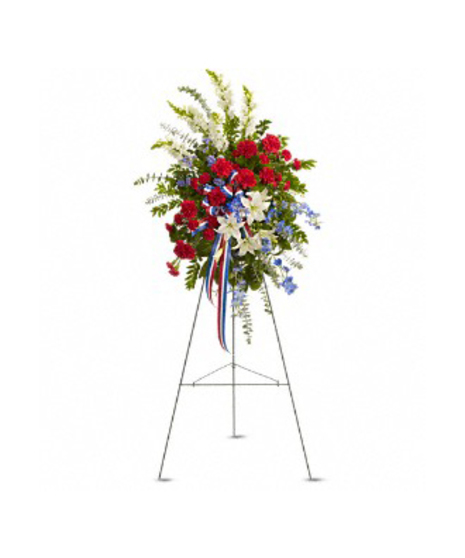 Patriotic sympathy spray of red, white and blue flowers presented on an easel