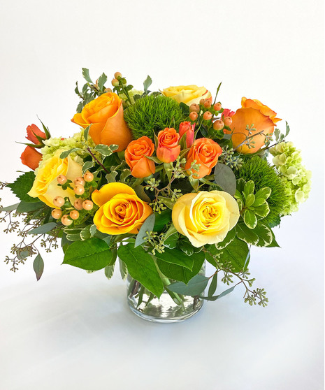 Clear glass cube filled with green, pink and coral flowers